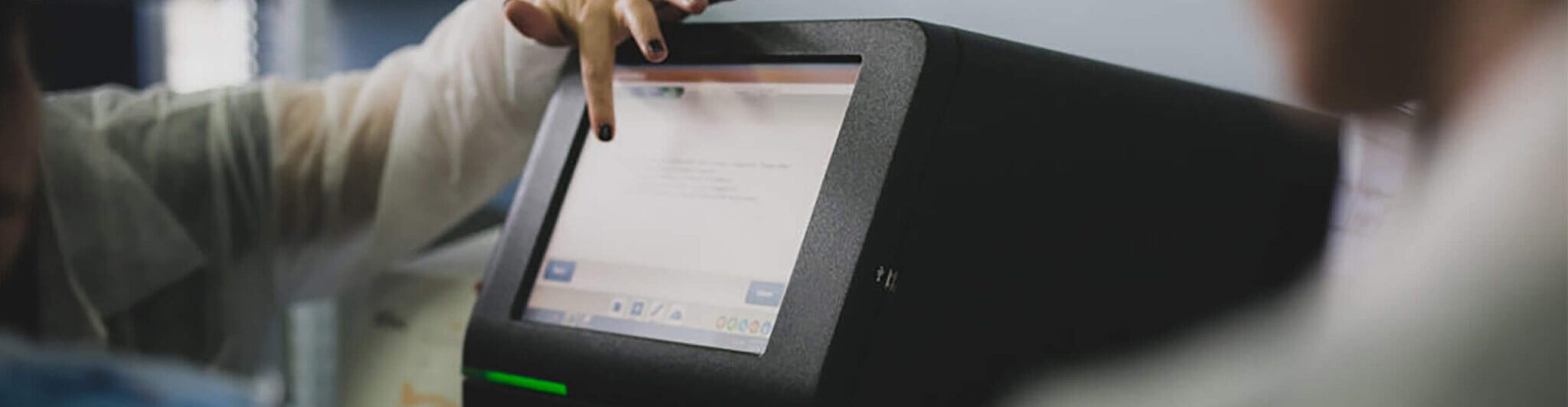 Image of a Next Generation Sequencing machine, with a scientist pointing at something on the screen