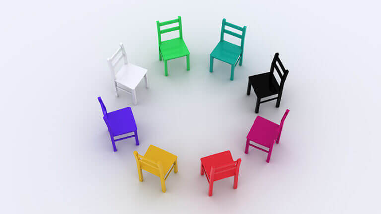 Group of multi-coloured chairs facing inwards in a circle