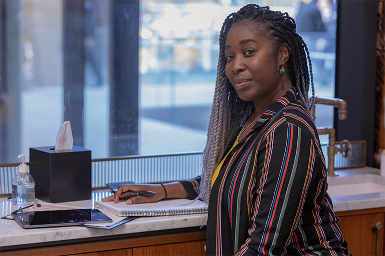 Photo of genetic councillor, Sasha Henriques, sat at her desk.