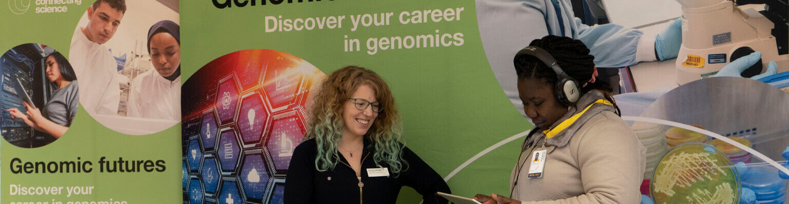Student looking at resources wearing headphones at the Wellcome Connecting Science Genomic Futures careers stand