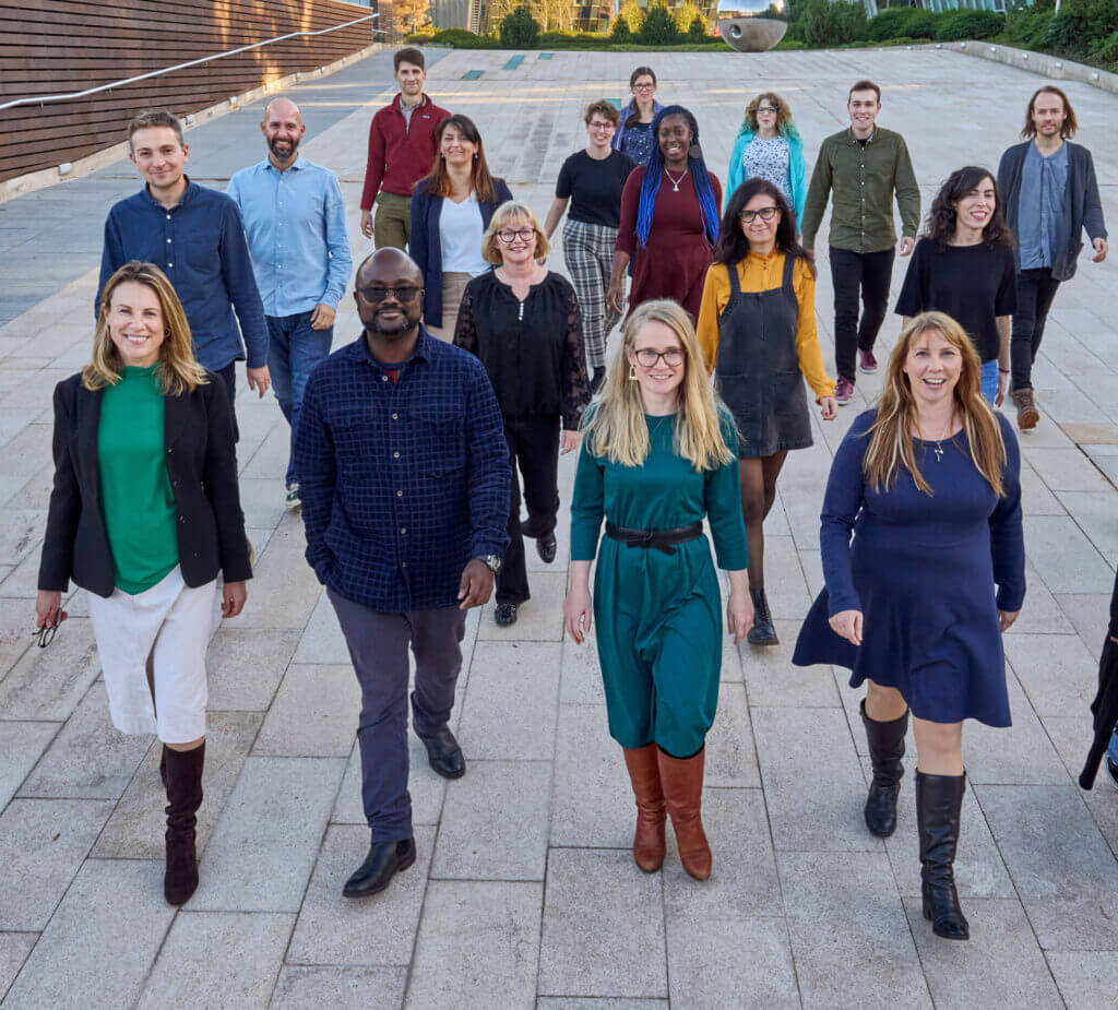 18 members of the Engagement and Society team, walking as a group outside.