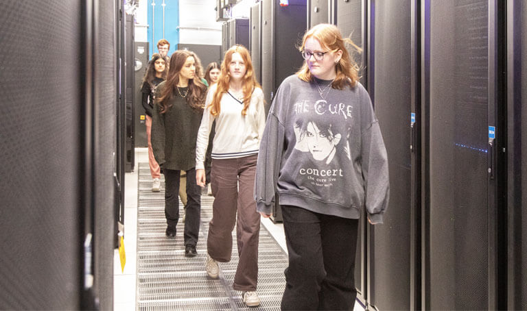 A group of young people are walking through a bioinformatics lab