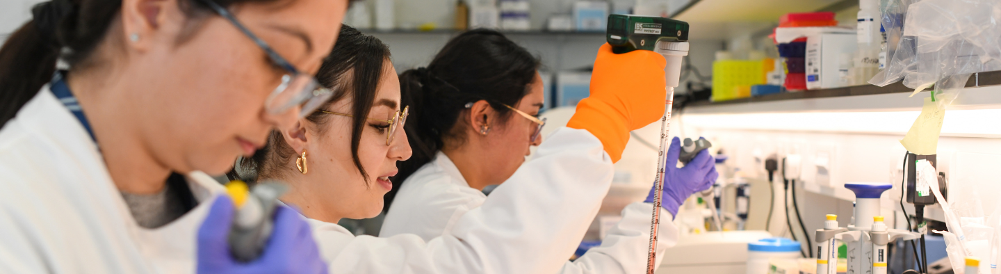 Three women working in a wet science lab